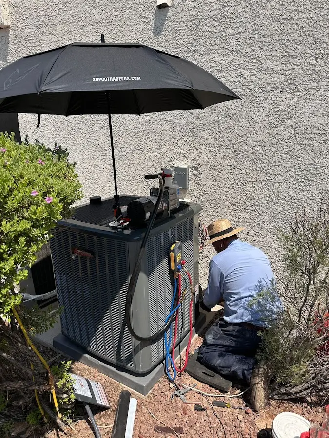 HVAC technician performing outdoor AC maintenance in Charlestown